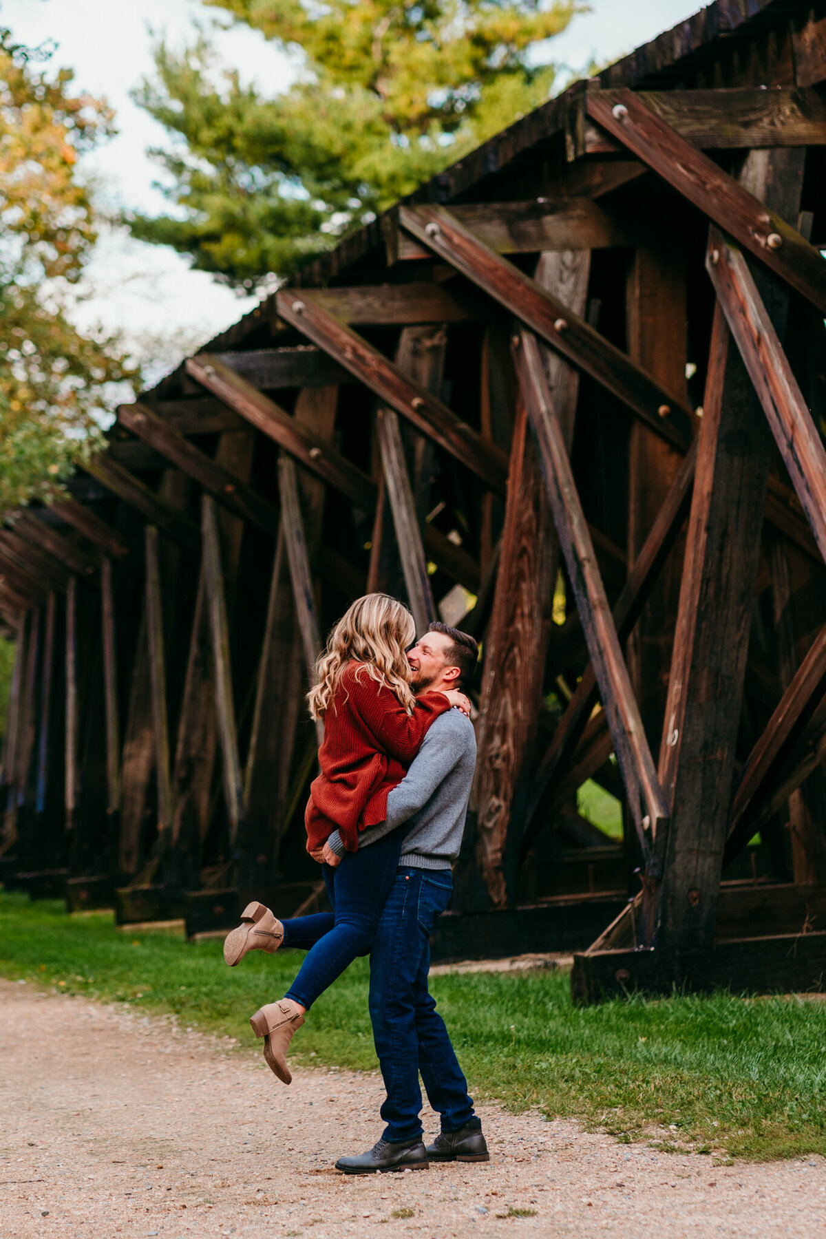  Couple holding each other under a wooden trestle bridge