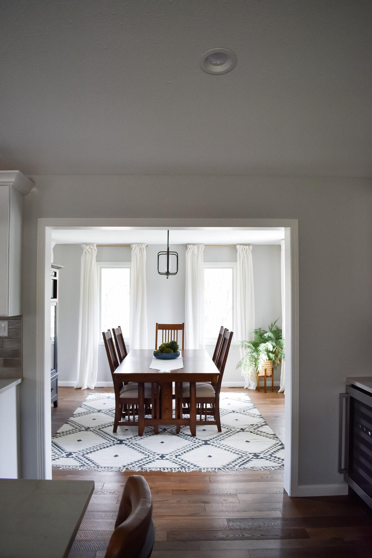 A large sqaure archway leads into a traditional dining room