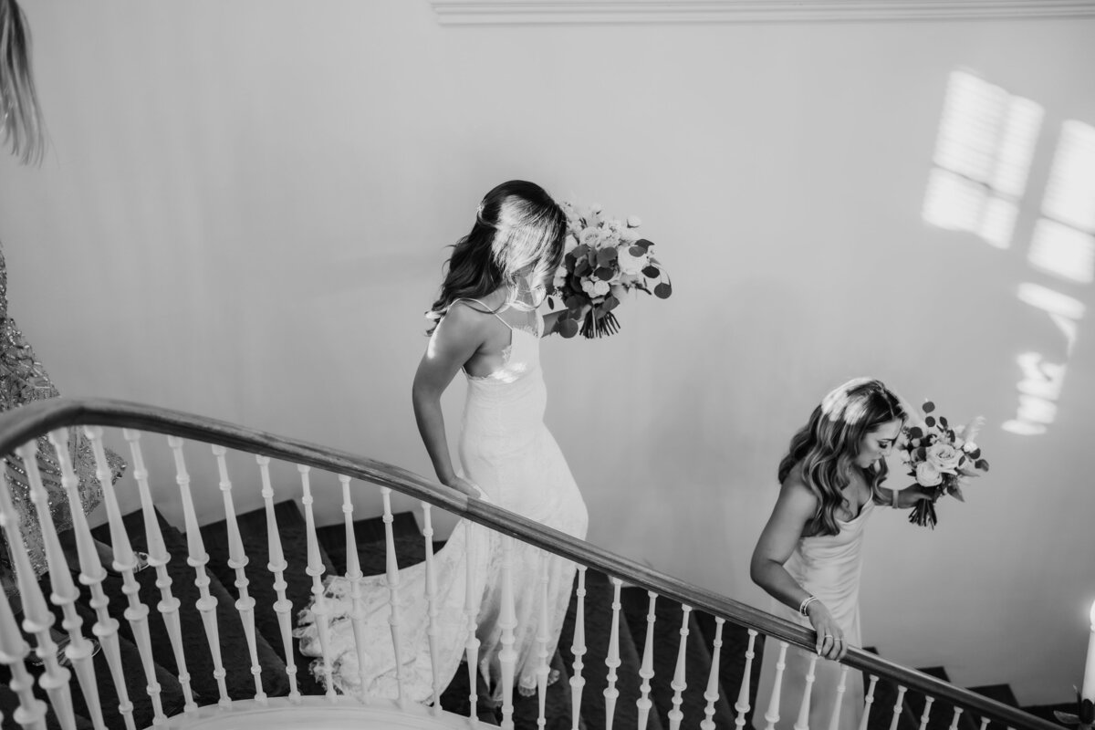 bride and bridesmaid walk down stairs