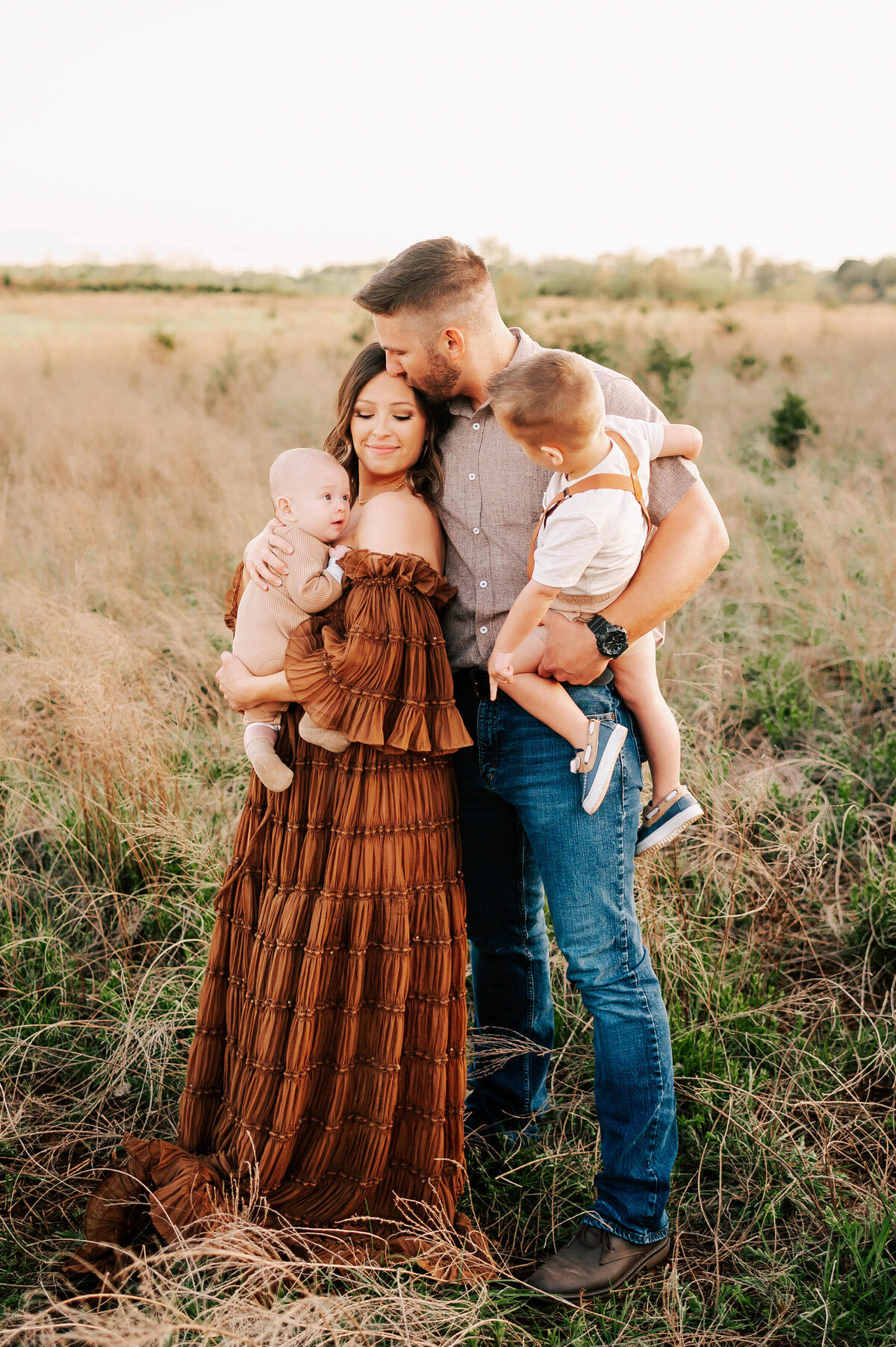 Branson MO family photographer Jessica Kennedy of The XO Photography captures family cuddling in a field