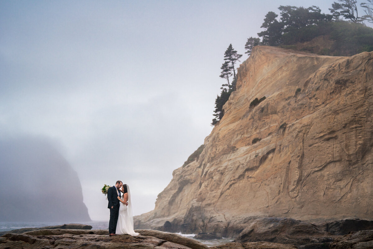A stunning landscape portrait of a bride and groom during their Oregon coast elopement wedding off the pacific coast highway