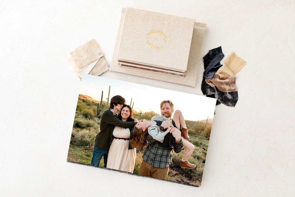 full-page maternity portrait in 8x10 album8x10 album open with full-page maternity portrait by Cactus & Pine Photography, surrounded by other album details on white tabletop