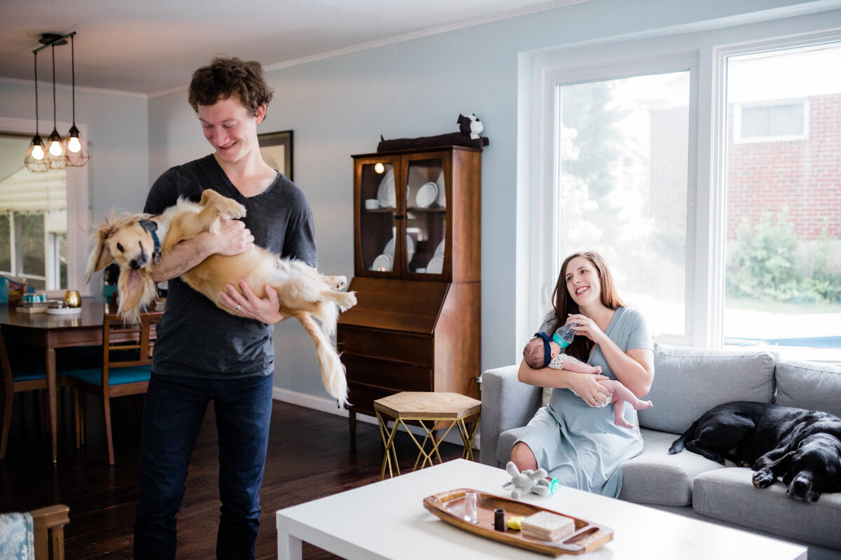 mom with baby and dad with doggy in candid photo