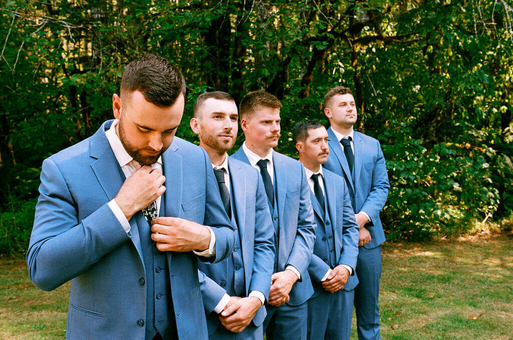 Groomsmen stand together outdoors at a vintage garden wedding planned by Birdie June Events.
