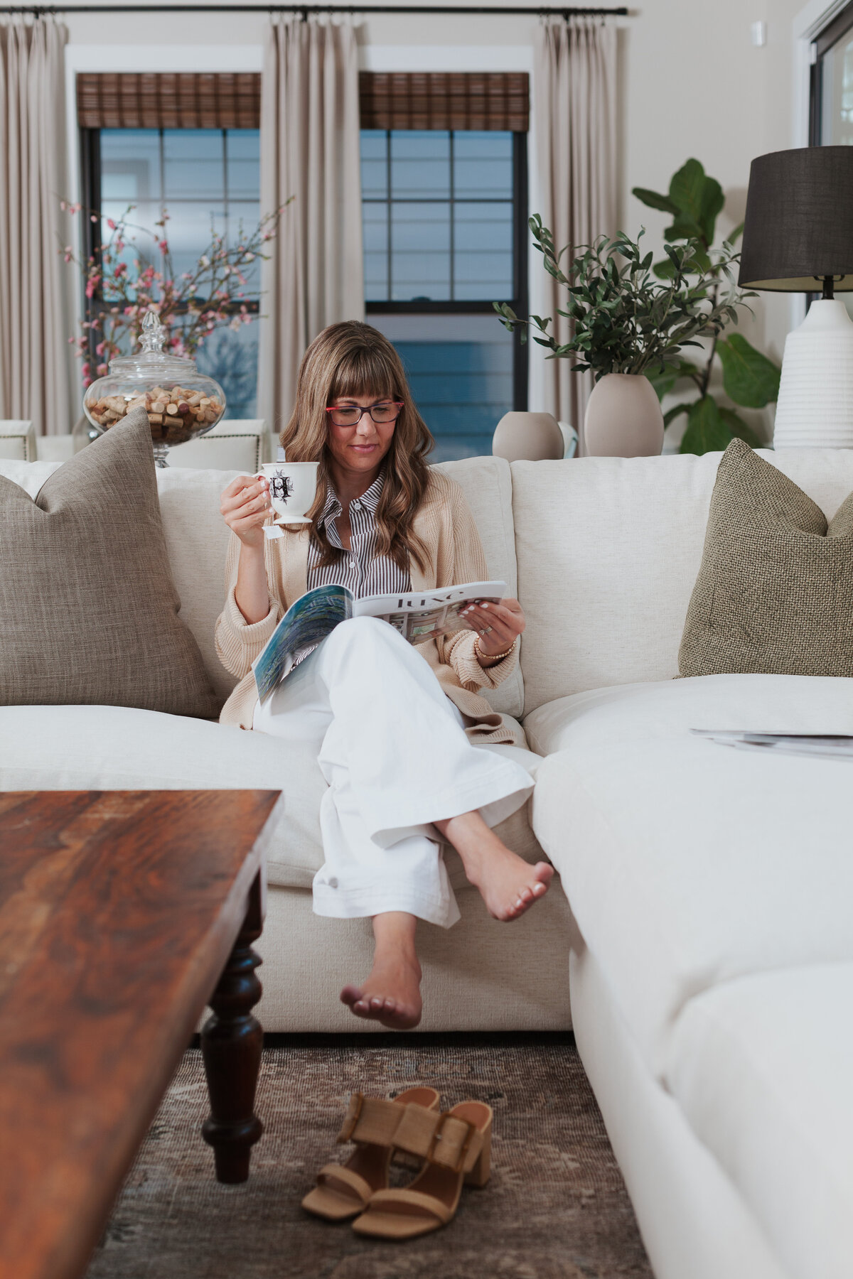 interior-designer-reading-design-magazine-on-white-sofa-for-brand-session-cotswold-charlotte