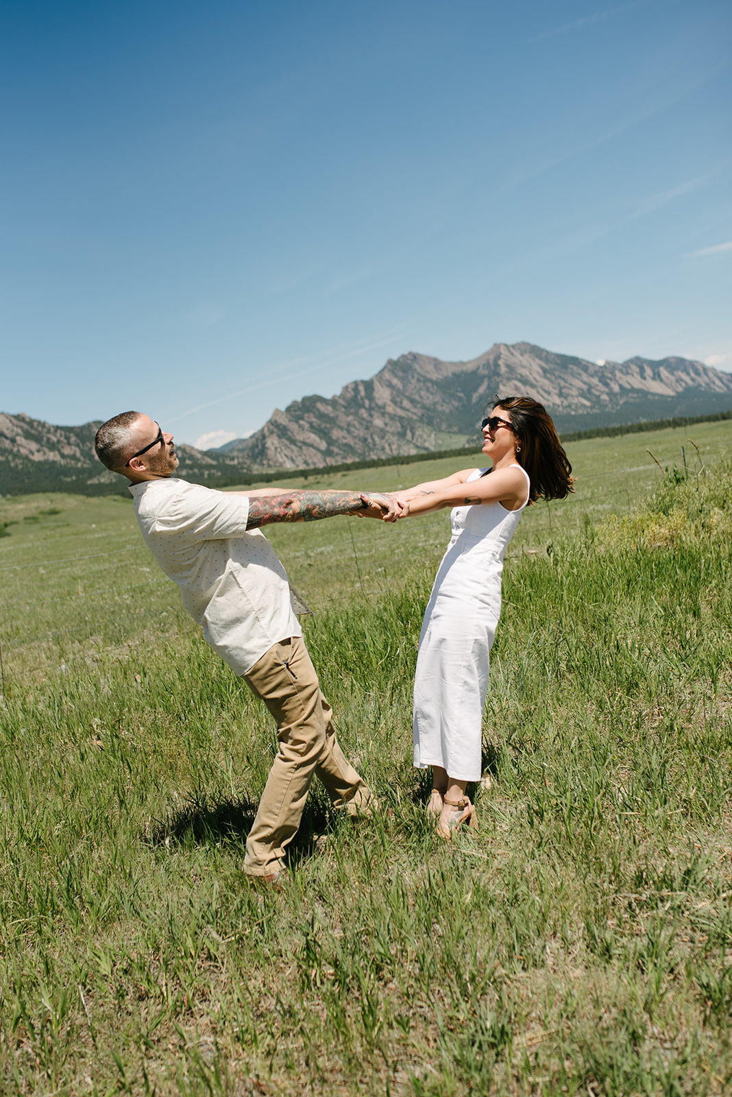 Couple laughing during engagement session in Denver’s foothills