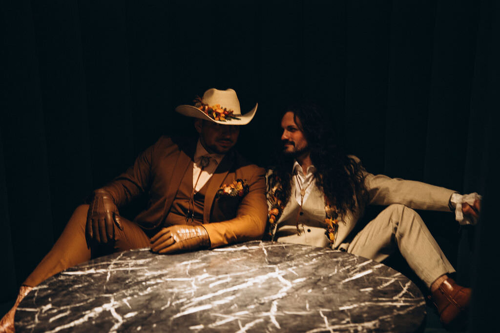 A couple lounging behind a table together.