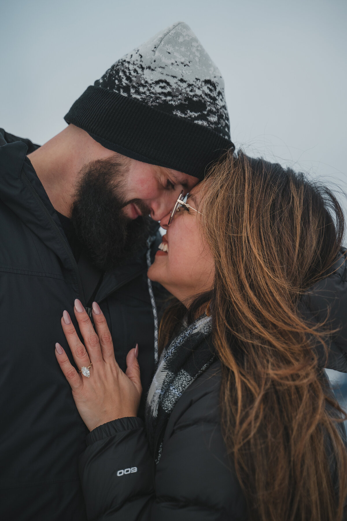 Close-up of couple hugging with focus on engagement ring in Banff.