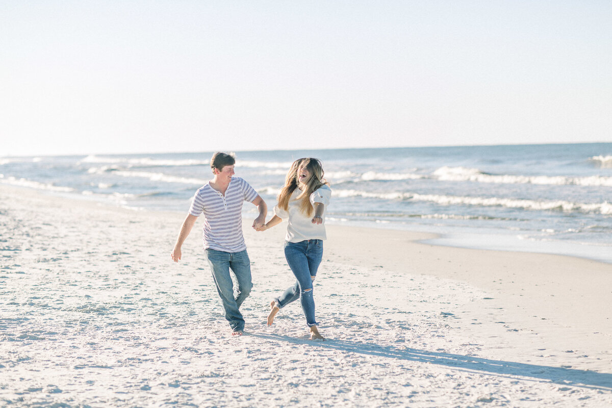 Running and laughing on the beach captured by Staci Addison Photography