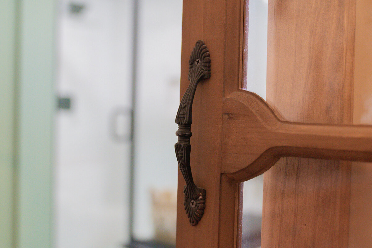 Antique door handle on wooden door with glass panels