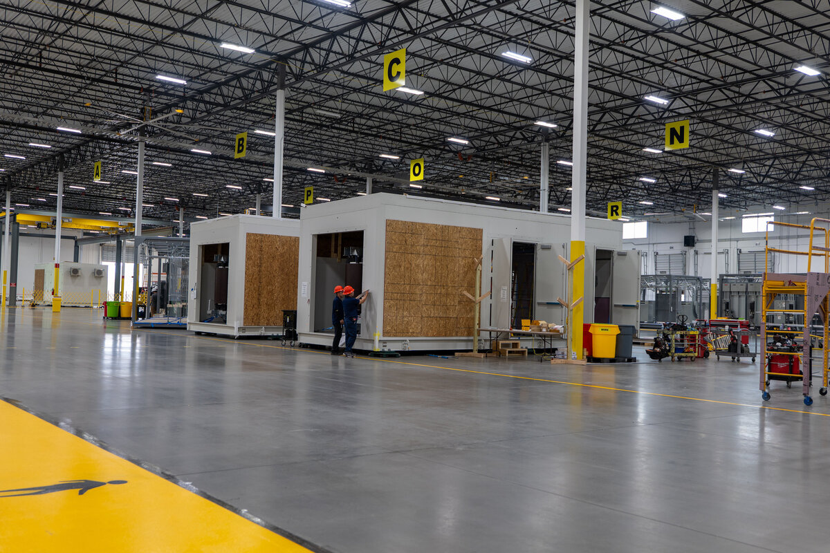 The inside of a warehouse with individual sheds in it