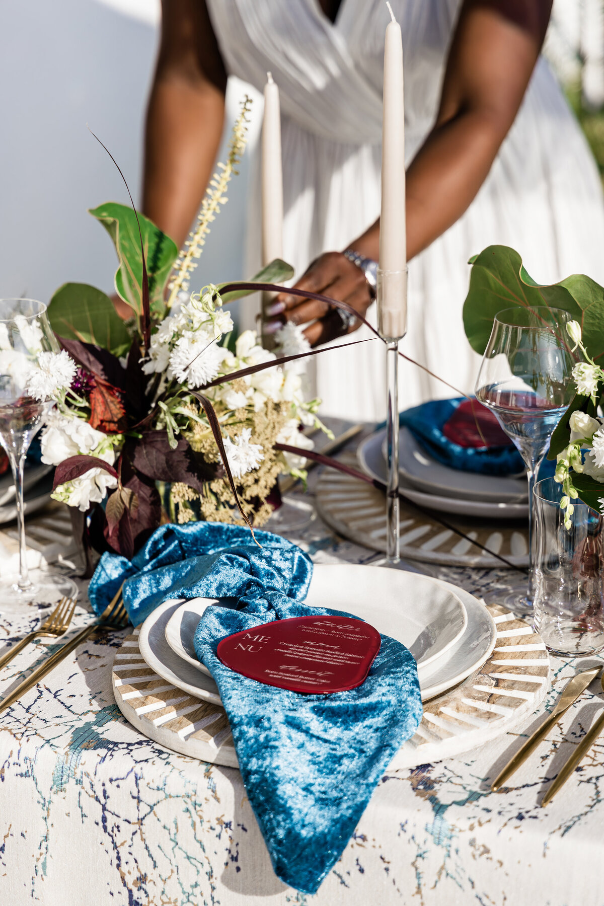 hands fixing ocean themed table setting