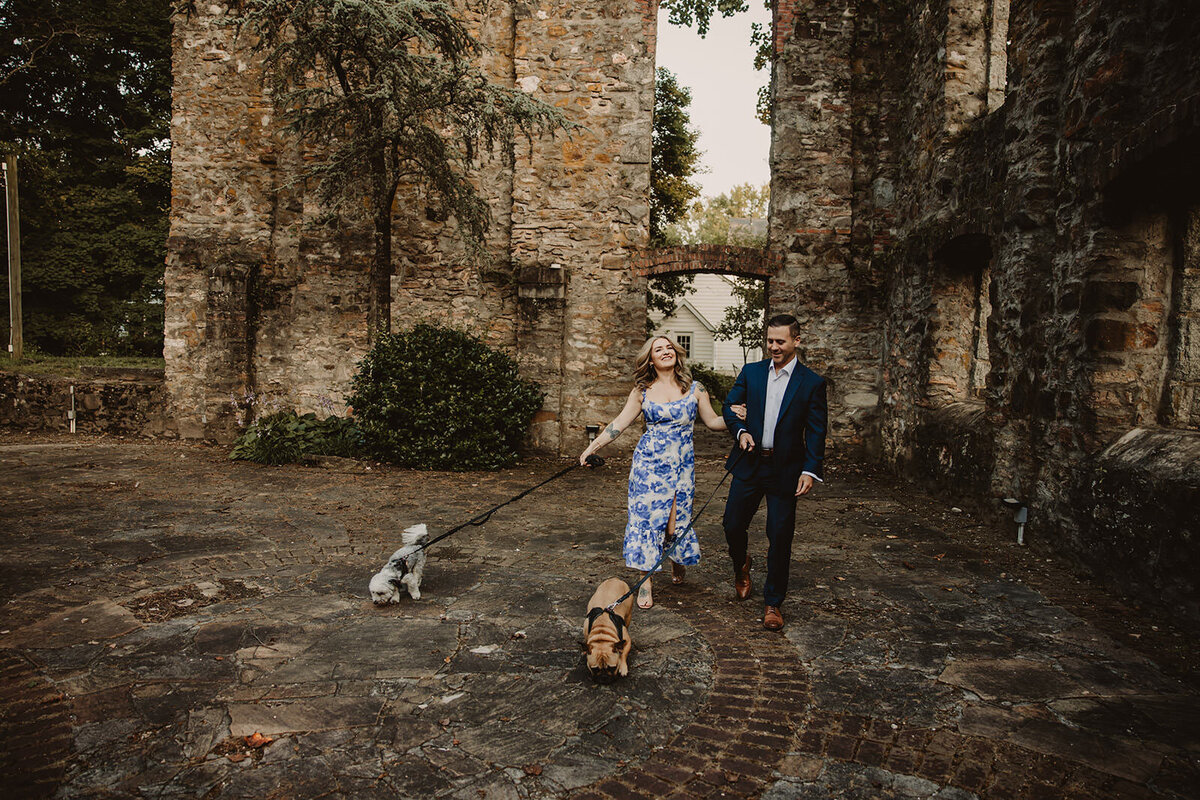 A couple walking together with their dogs 