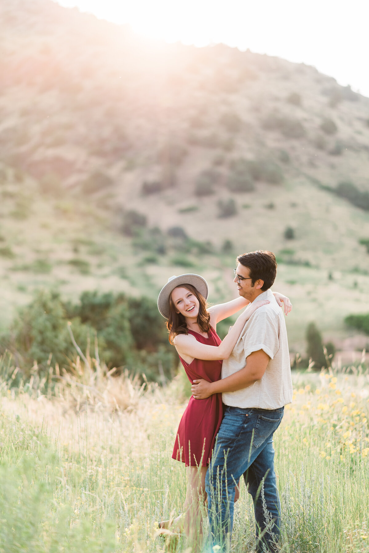 Couple dances in a field with the foothills behind them