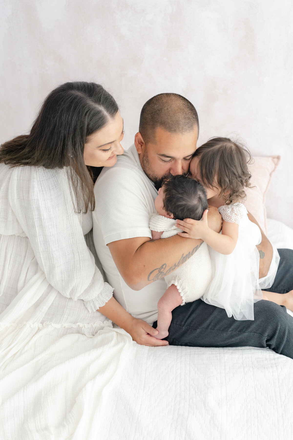 Family cuddling baby during natural light Barrie newborn photography session 
