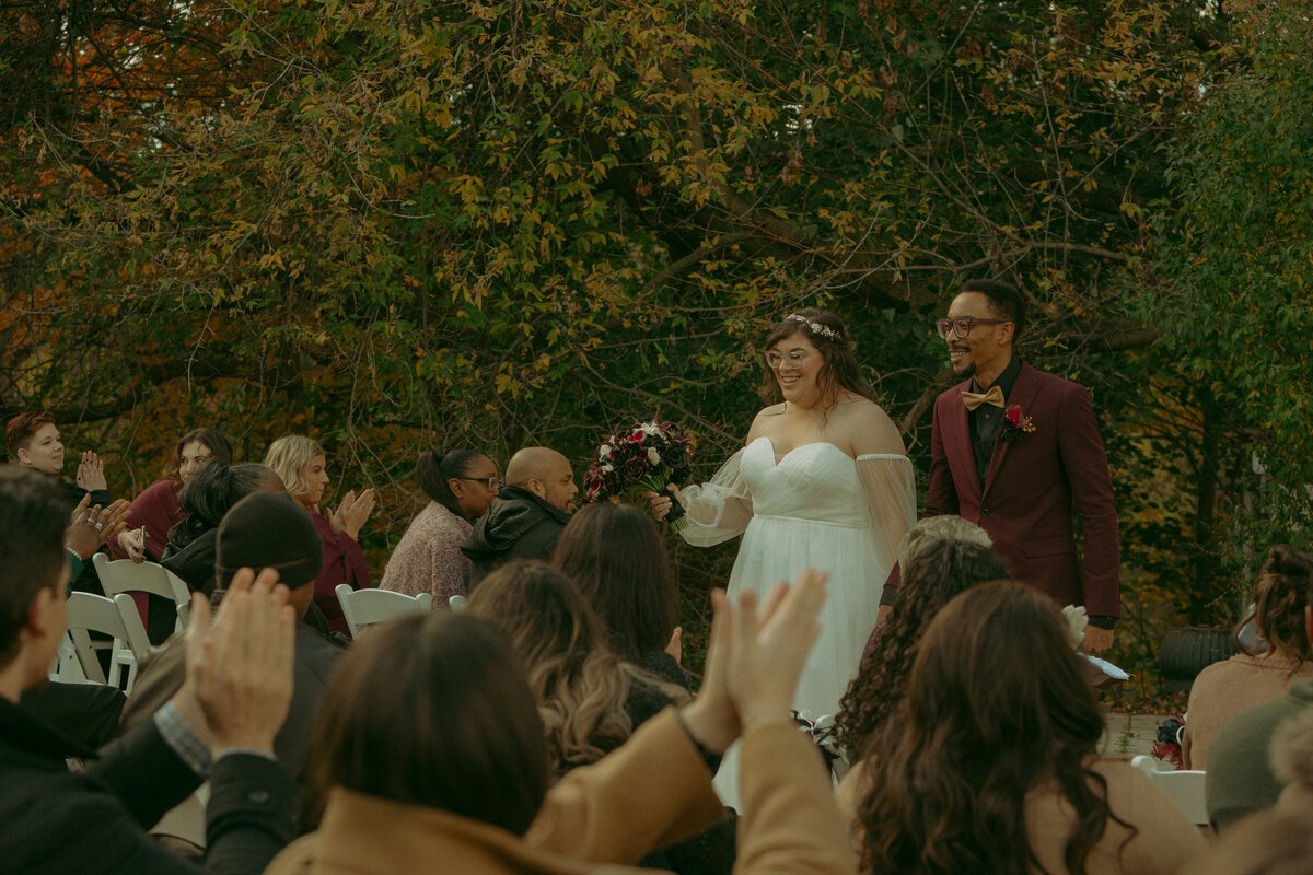 Man and woman romantically spin around, laughing in the middle of a  flowery field