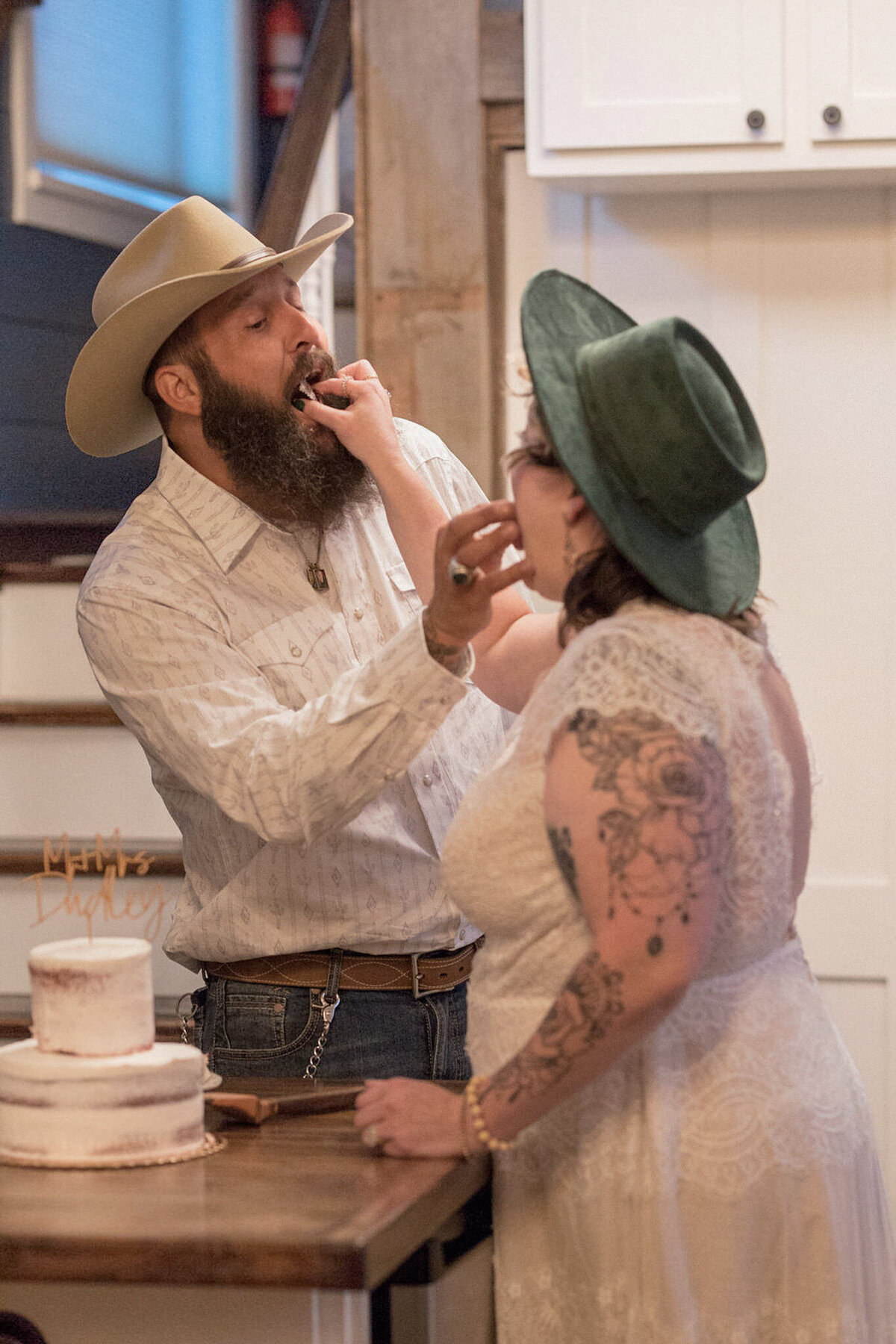 The bride and groom feed each other a bite of their wedding cake inside their tiny house in the Colorado foothills.