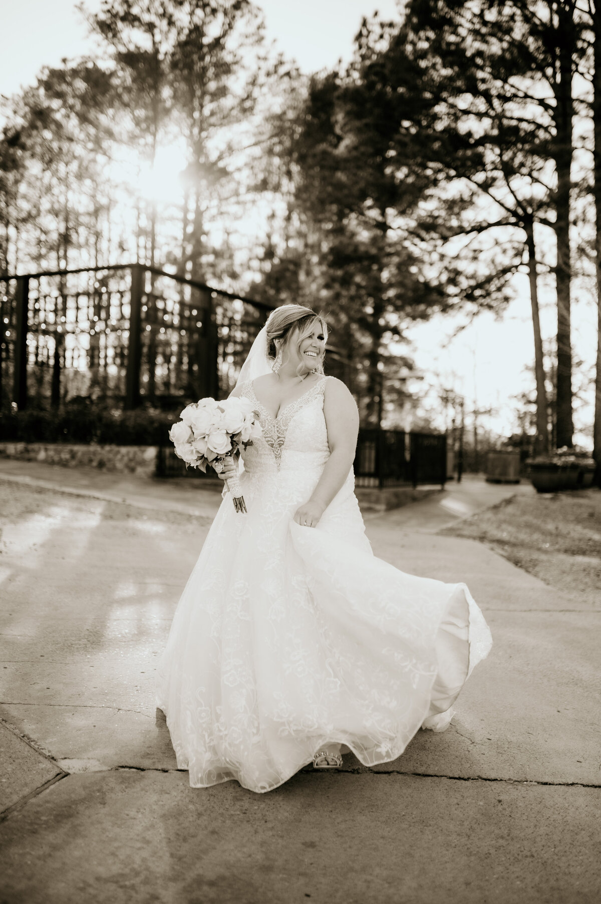 bride carrying her dress and twirling around as she dances during her sunset bridal session with best Little Rock wedding photographer