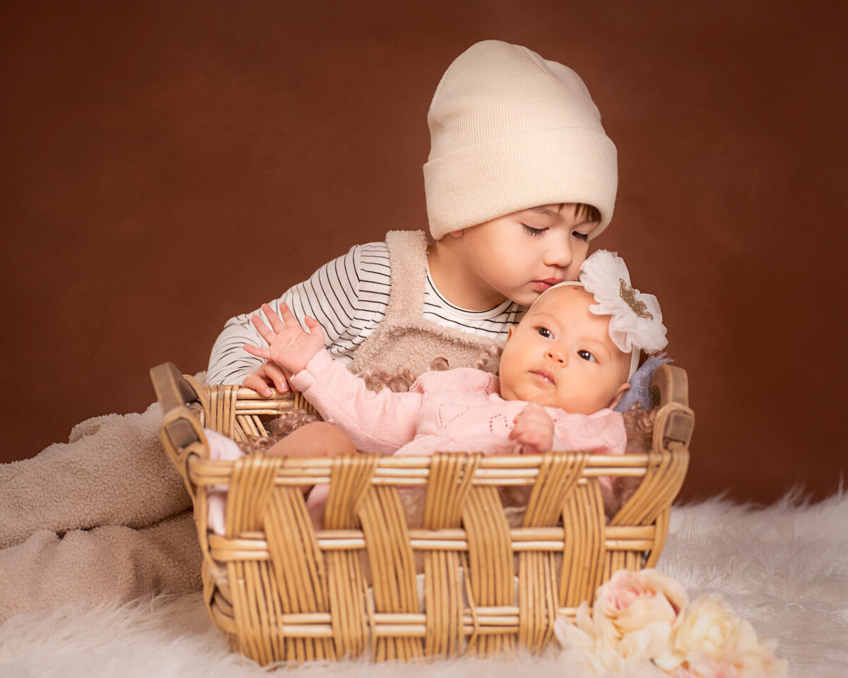 Newborn posed in a rustic basket wearing an adorable knit hat, captured in Overland Park, Kansas. This cozy setup is ideal for families seeking warm and timeless newborn photography