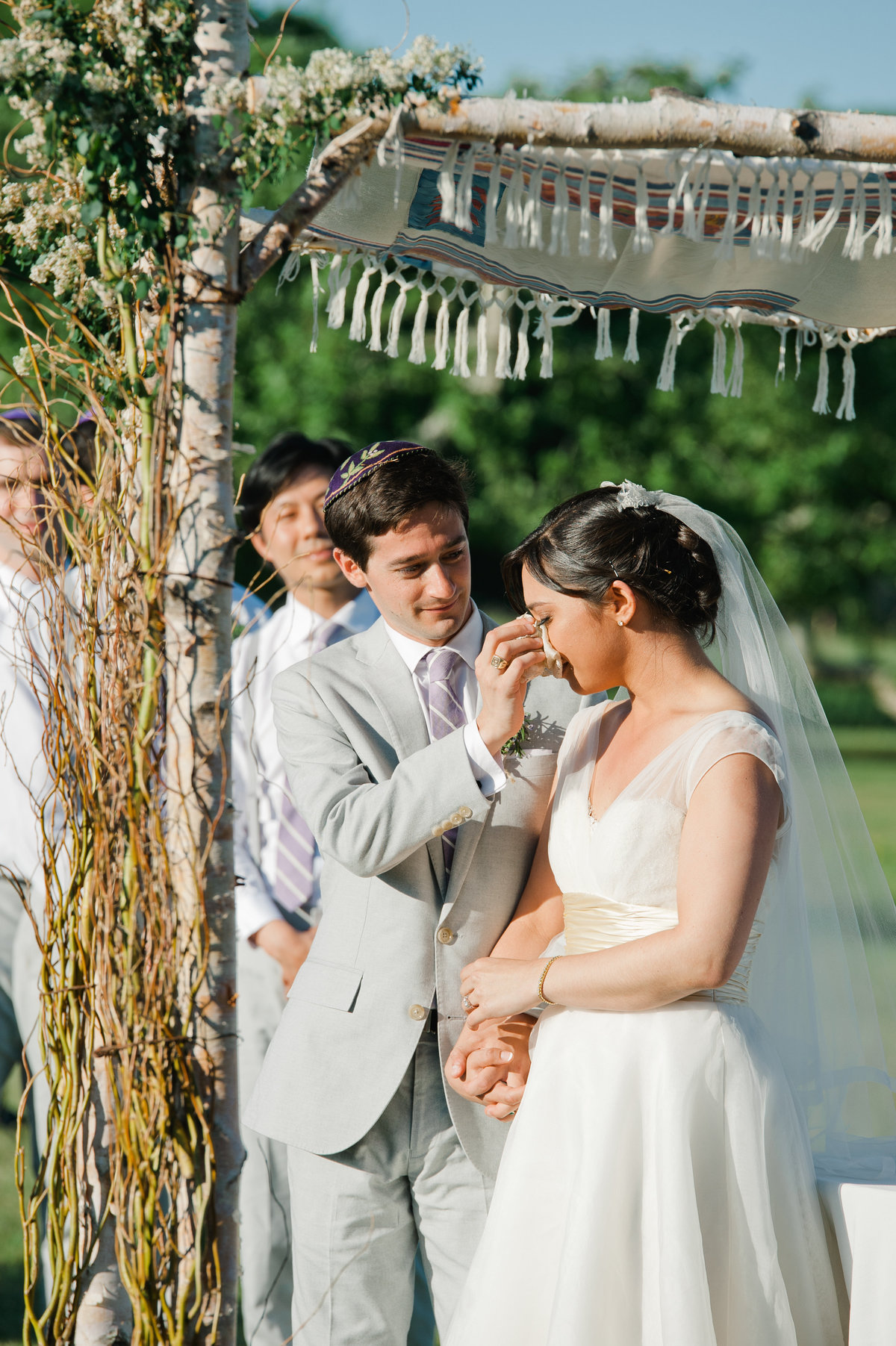 Groom wipes away bride's tears during ceremony