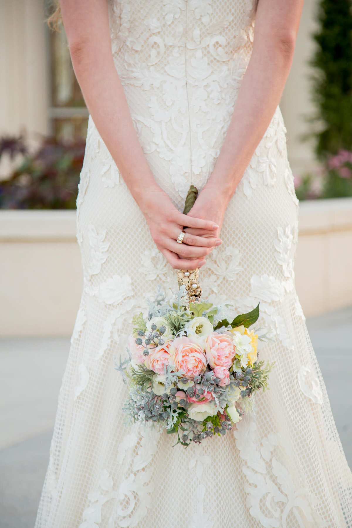 a bride holding a bouquet behind her