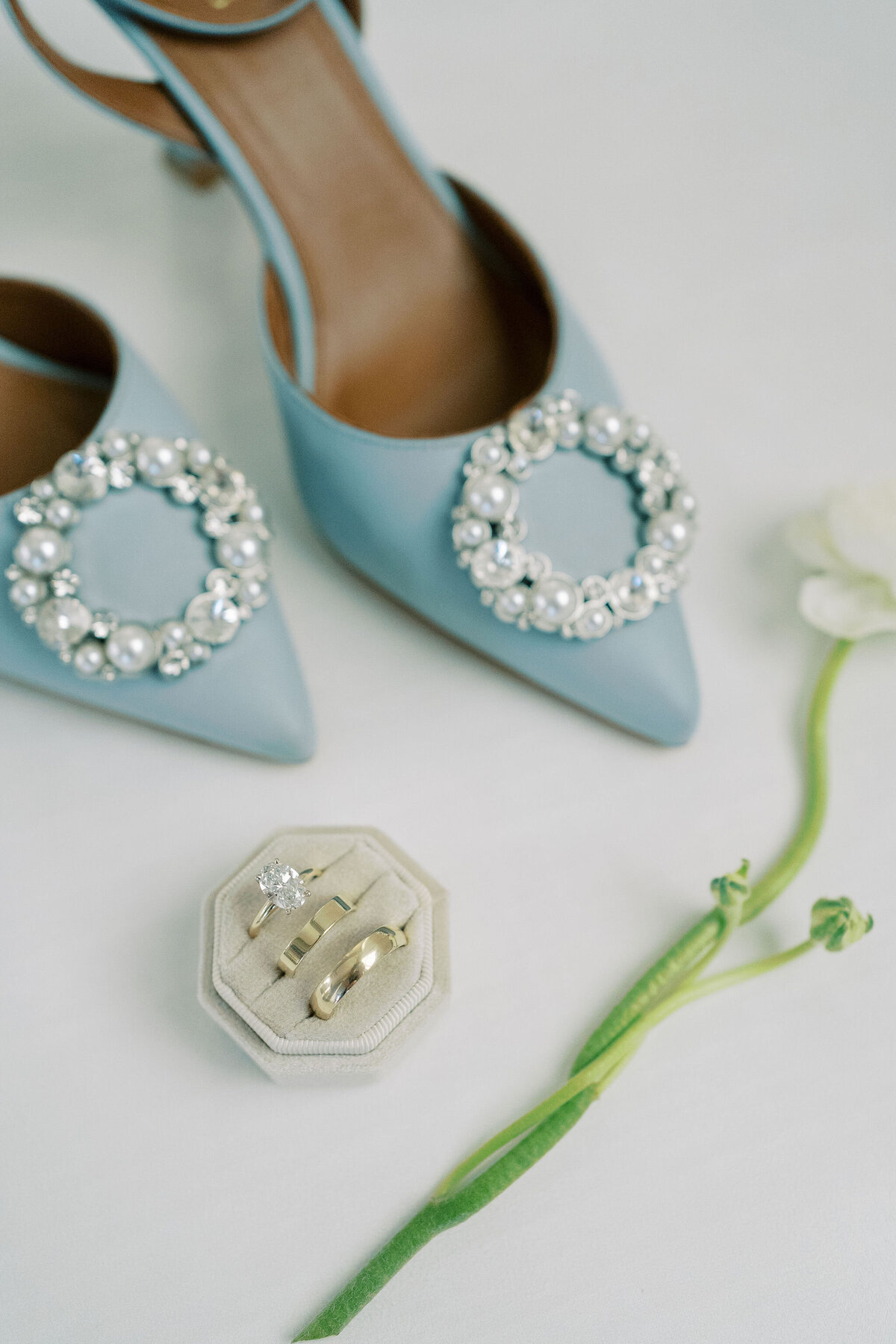 close up of bridal shoes and wedding rings