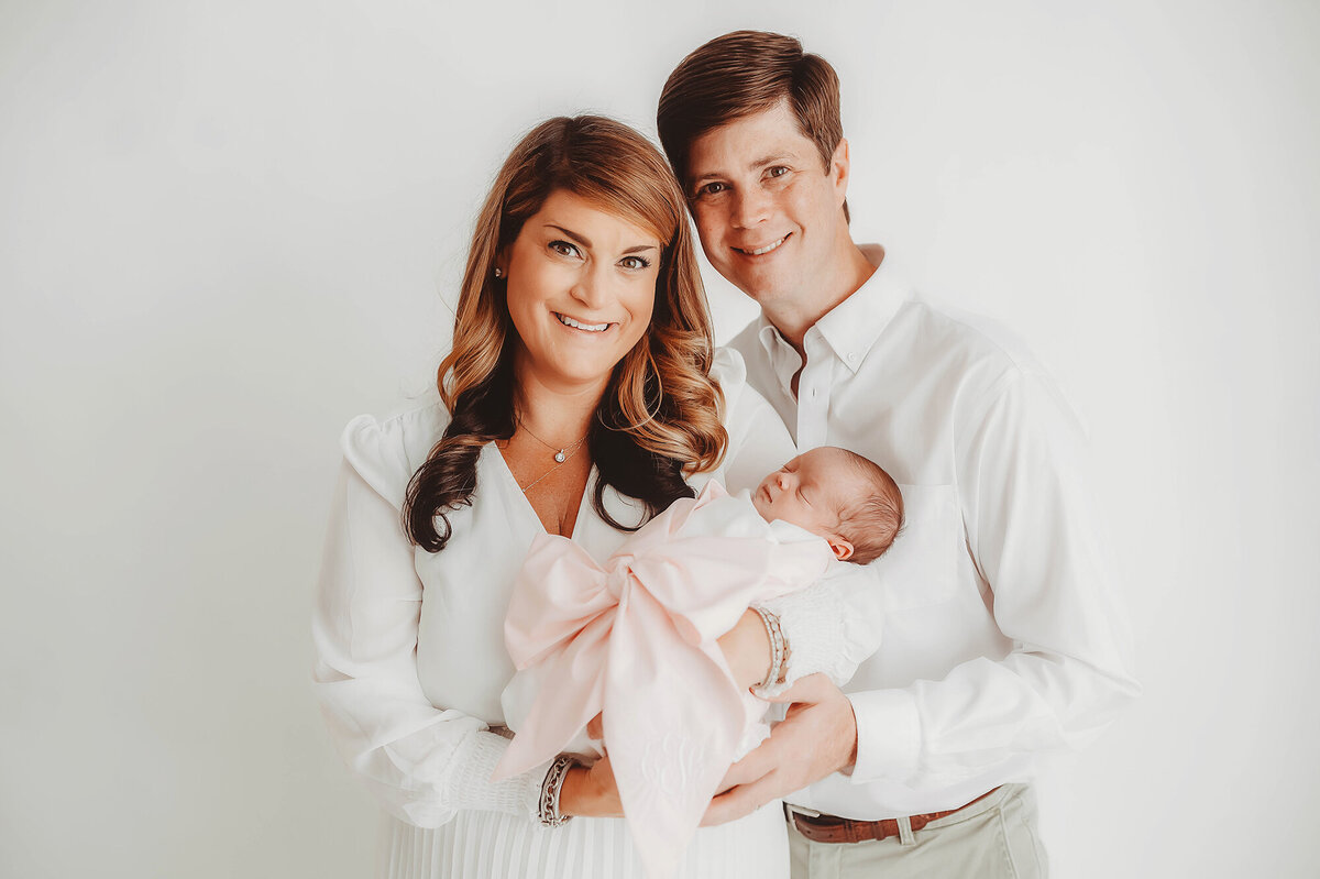 New parents embrace their newborn baby during Newborn Photoshoot in Asheville, NC.