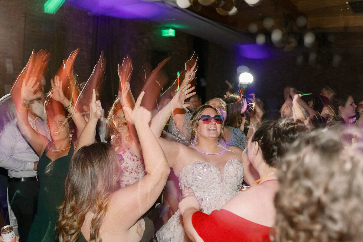 Bride dances in her sunglasses  at her wedding reception in Denver, Colorado.