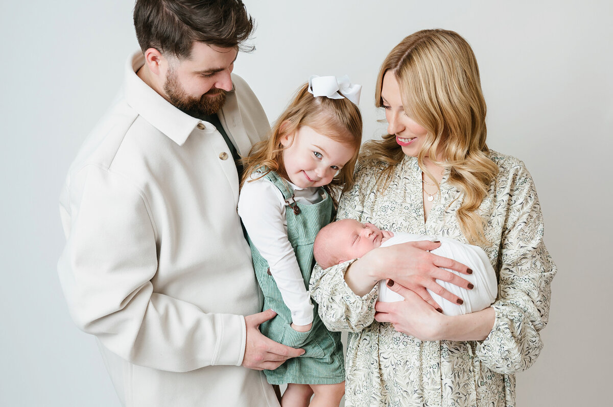 Family sharing the joy of their newborn during a photoshoot in Bridgeville, PA, with Katie Louise Photography
