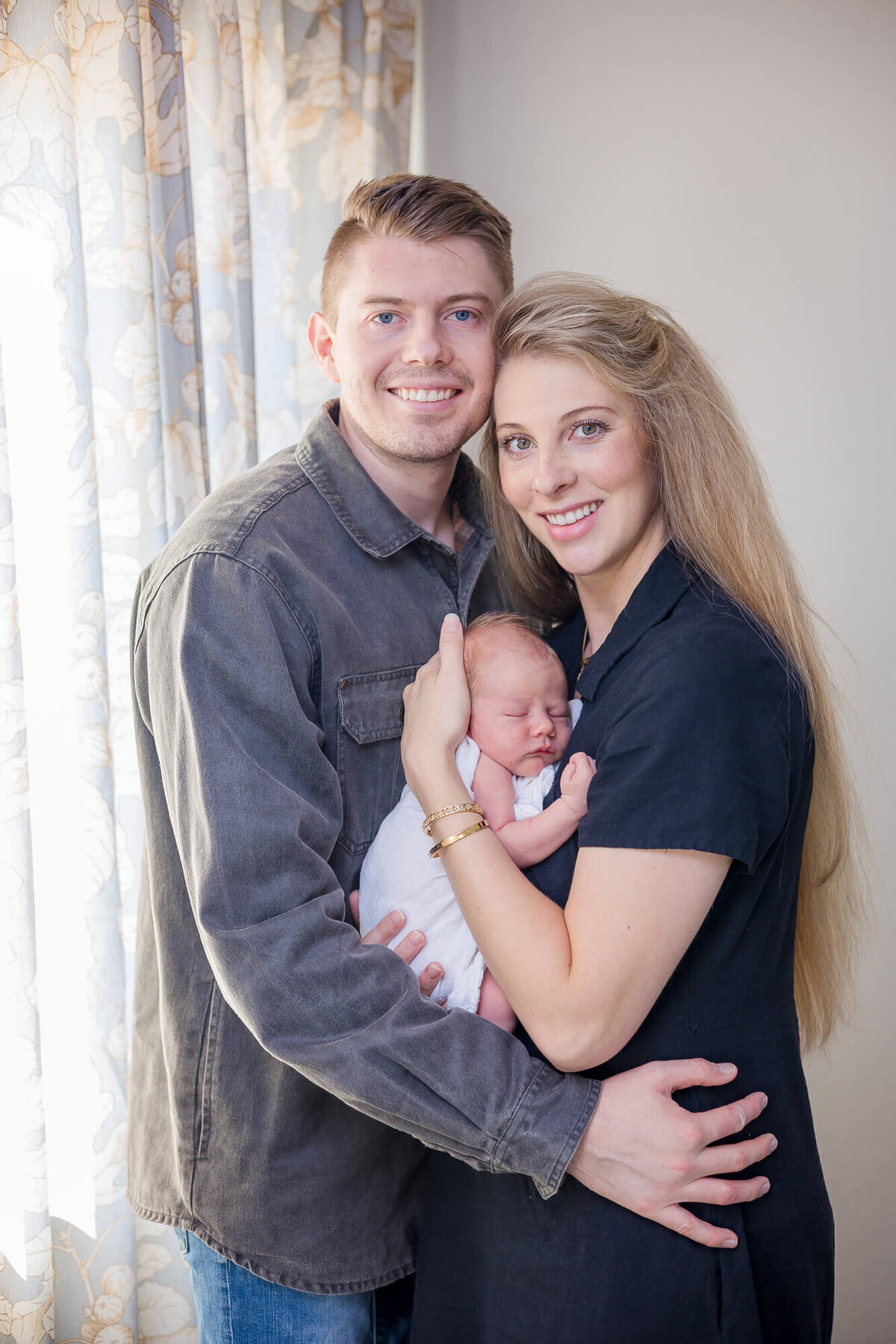 Newborn baby boy held by his parents during his lifestyle in home newborn session in Las Vegas