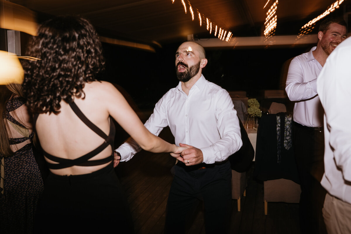Friends dancing together at indoor wedding party