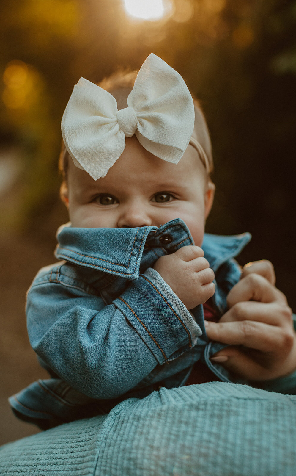 baby girl wearing jean jacket and big white bow