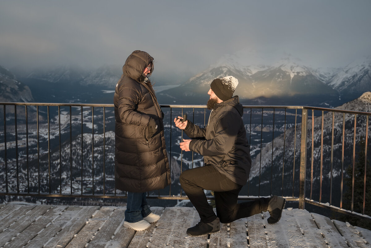 Man proposes at golden hour on a Banff mountaintop with panoramic views of the Canadian Rockies.