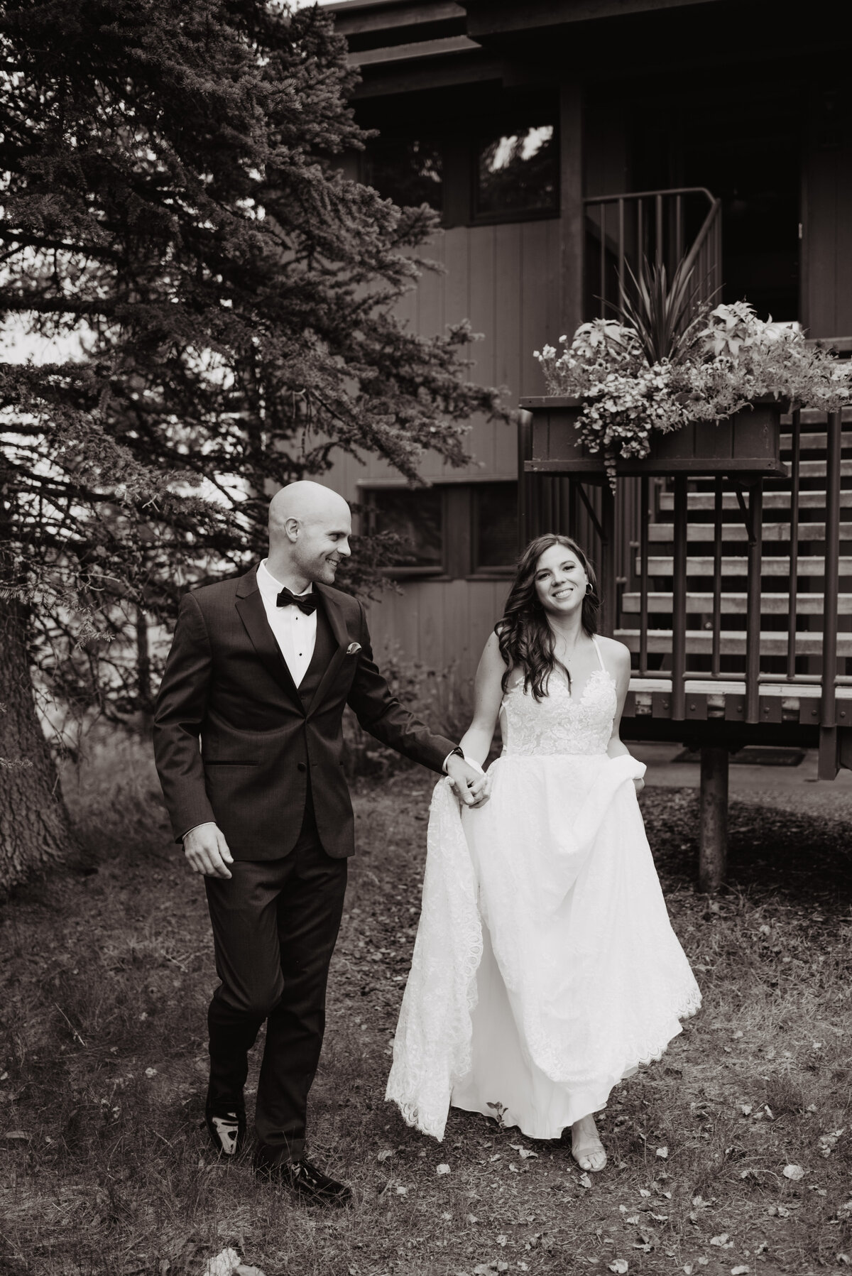 Jackson Hole photographers capture bride and groom walking into forest