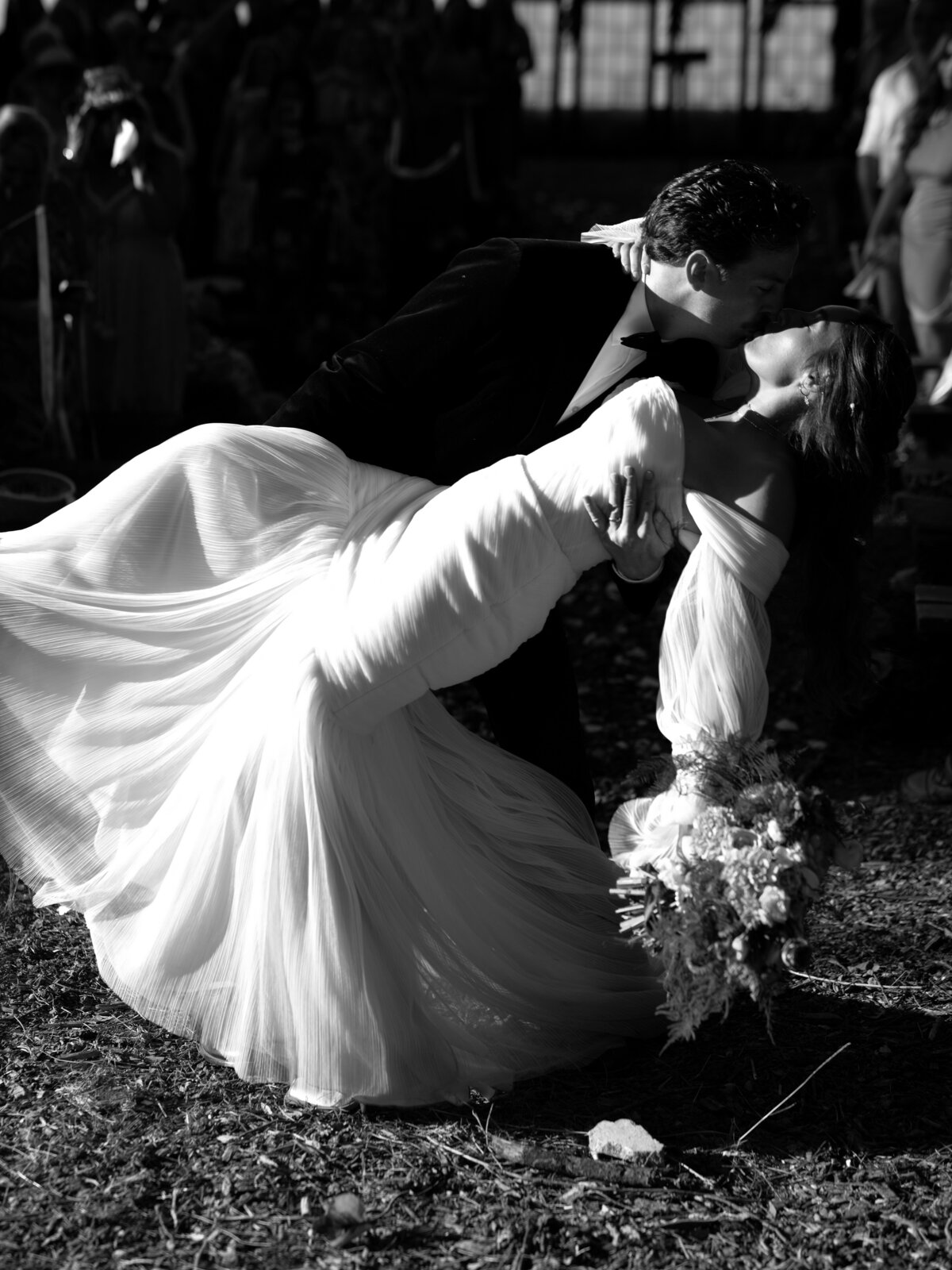 groom dipping bride down for a kiss after wedding ceremony