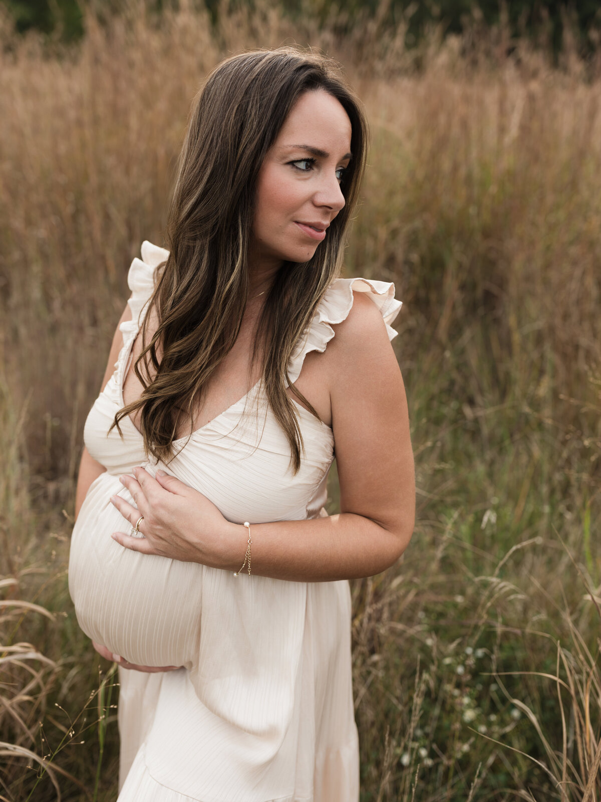 pregnant mother in pink silk maternity gown holding baby bump for maternity photoshoot cleveland maternity photographer