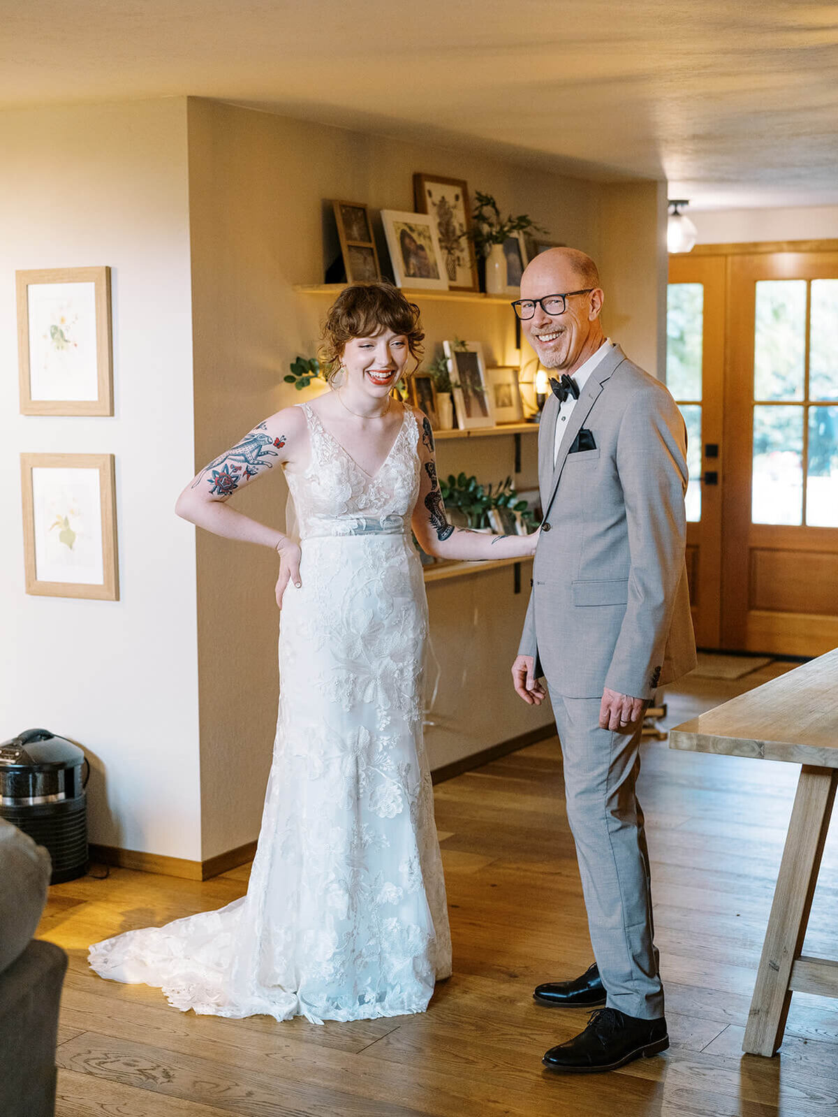 A bride and her father smiling and laughing on her wedding day. 