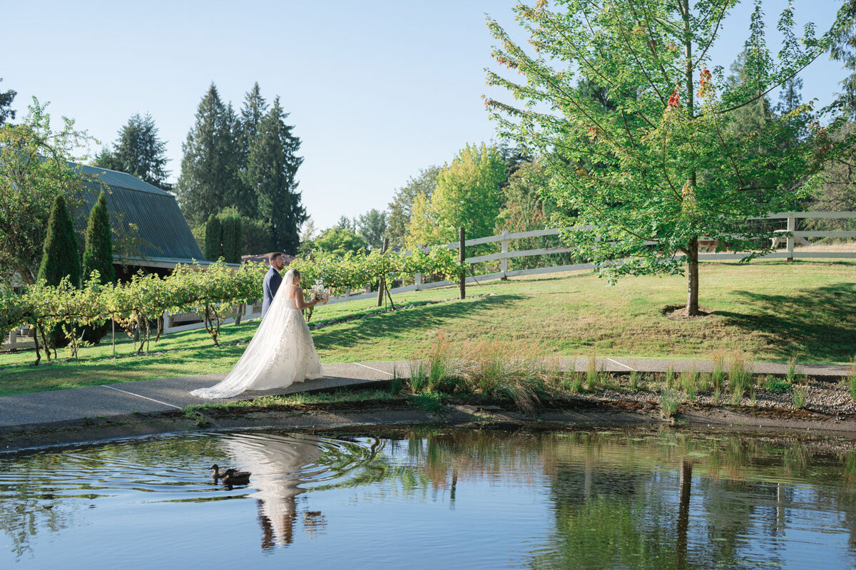 bride and groom walking by the pond