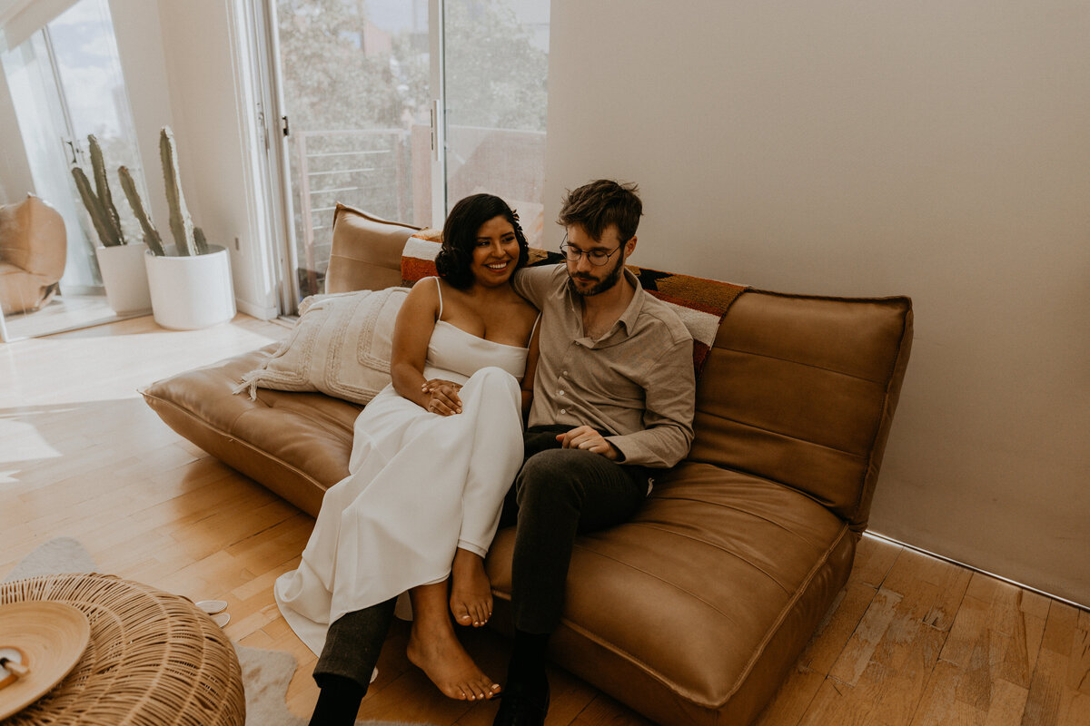 bride and groom sitting on a couch together before their wedding