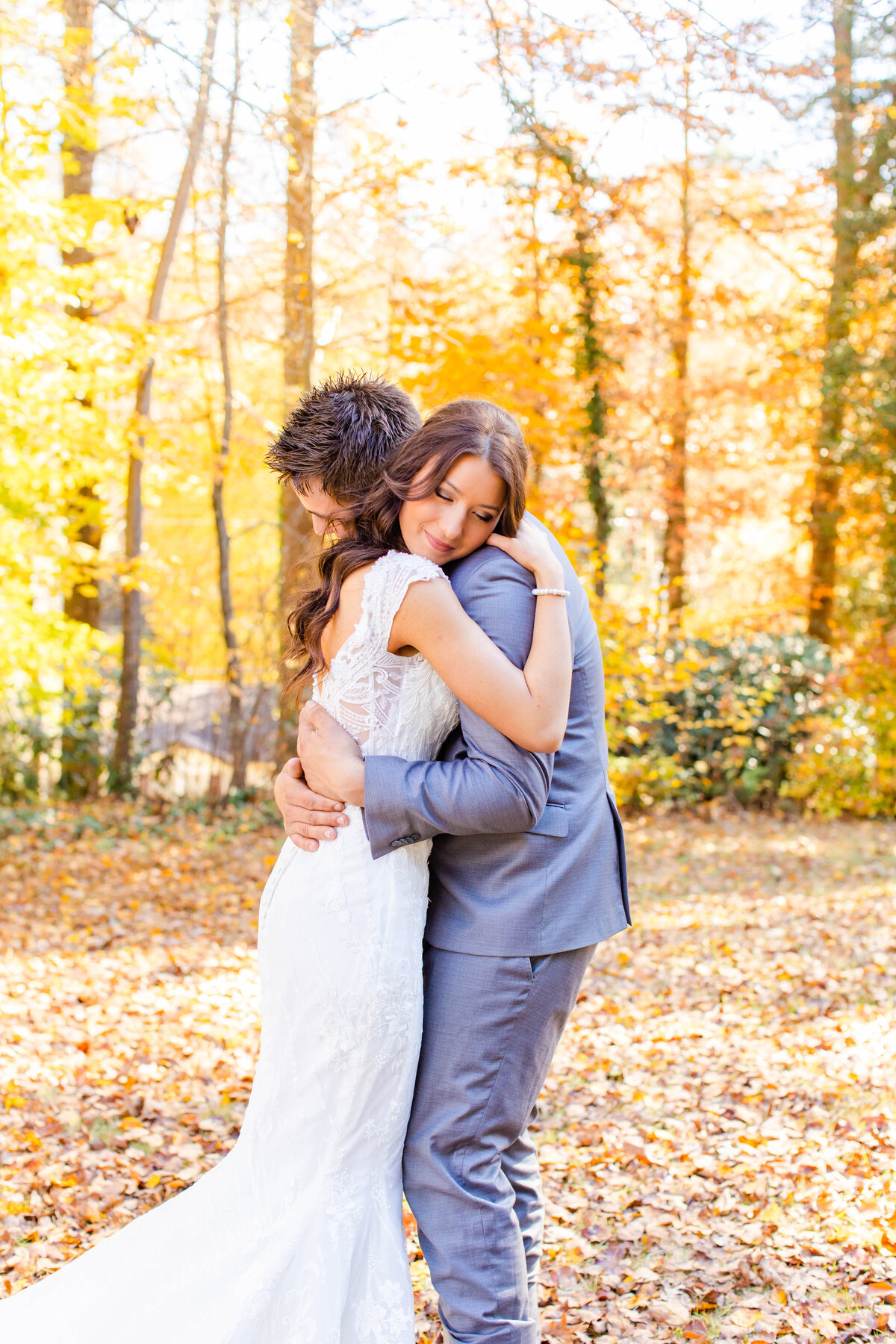 bride and groom hugging in fall setting