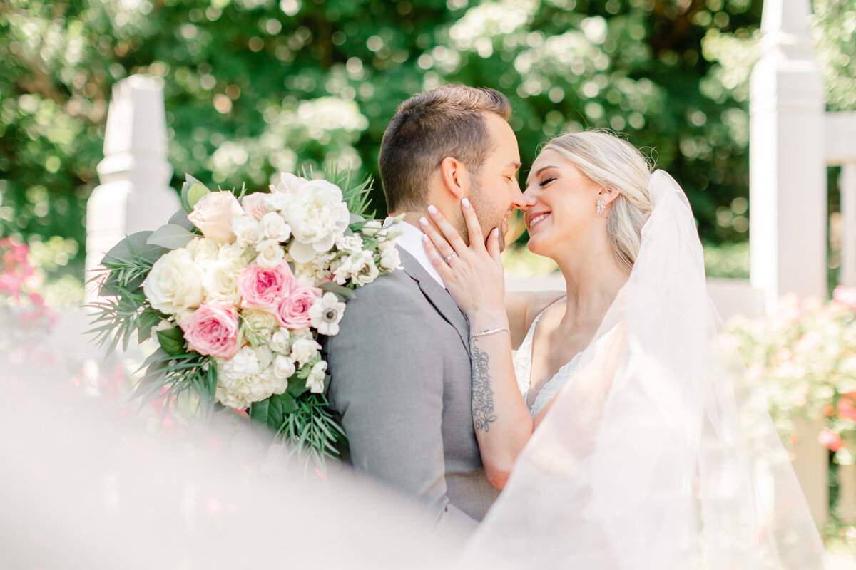 bride and groom at their wedding with faces almost kissing and veil in front by florida wedding photographers