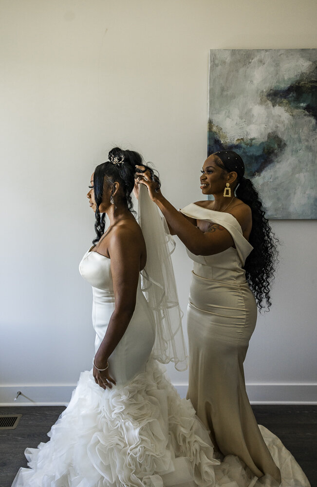 Woman pinning a simple vail in the brides hair