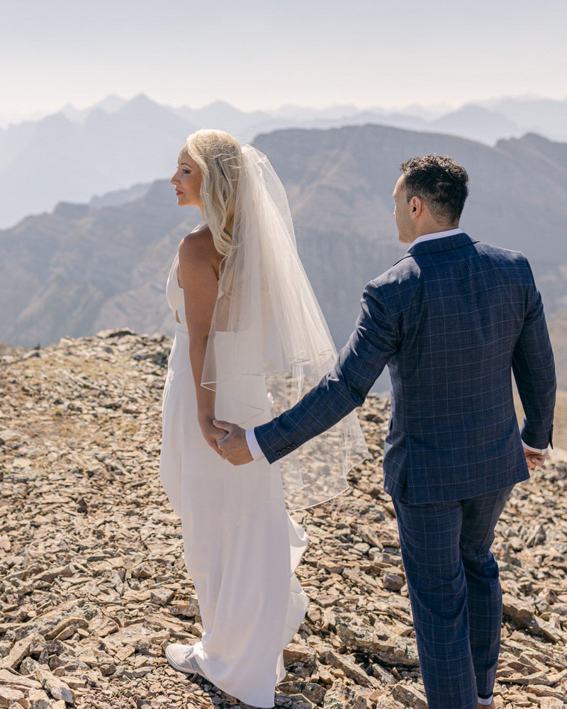 This breathtaking photograph captures the bride and groom at the top of Medicine Wheel after their helicopter wedding in Banff National Park. The stunning mountain views and adventurous setting reflect the uniqueness and grandeur of their special day.