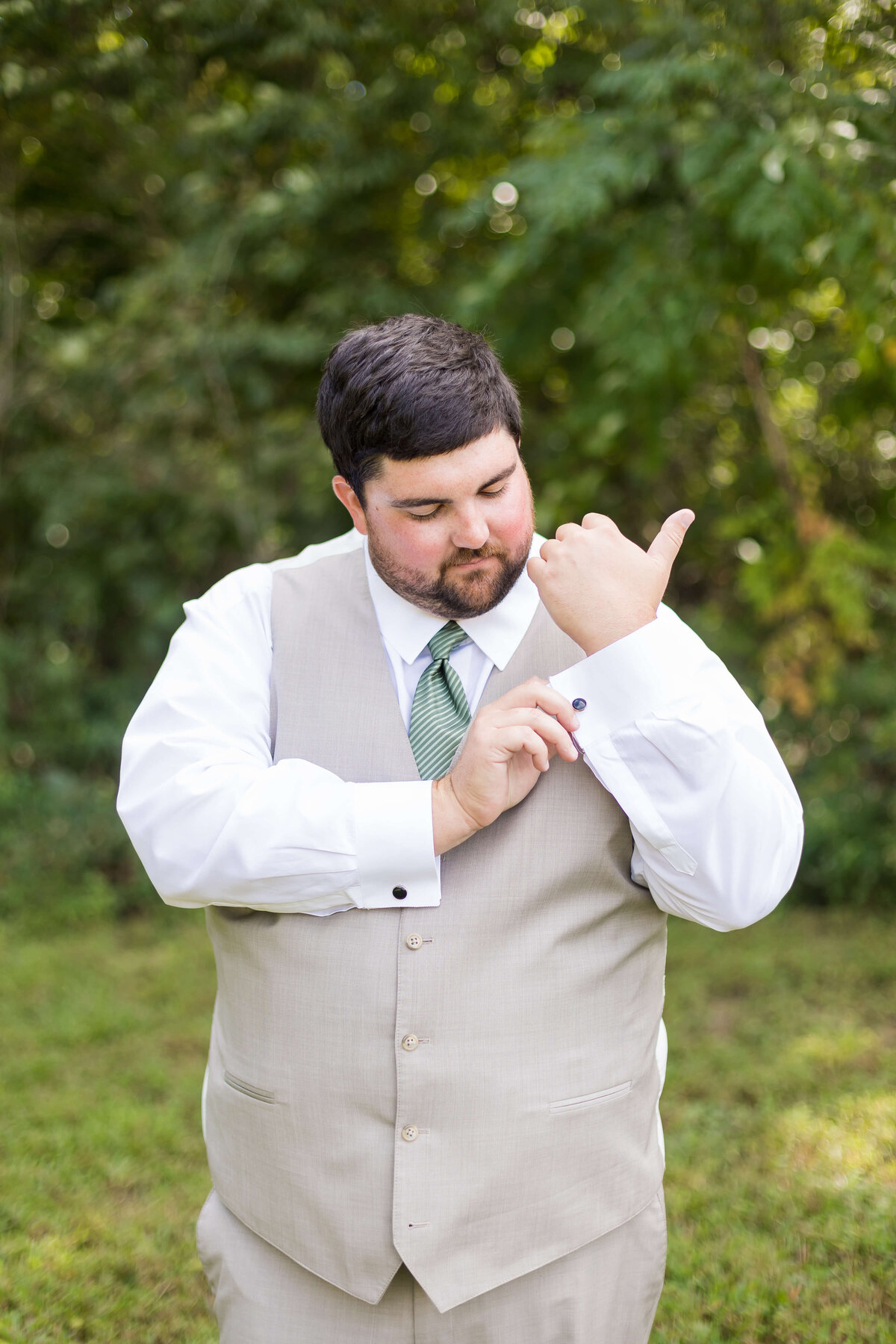 Groom fixing suit at  The Barn at White Oaks, Murray, Kentucky