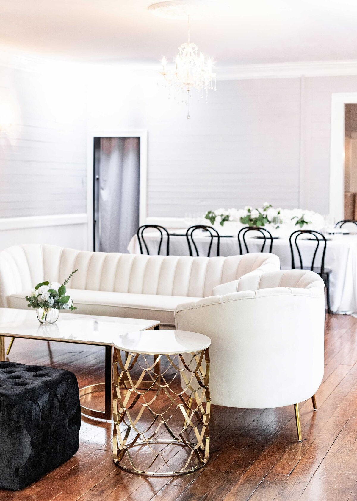 Elegant white sofas paired with black dining chairs create a sophisticated atmosphere for high-end corporate events in Raleigh.