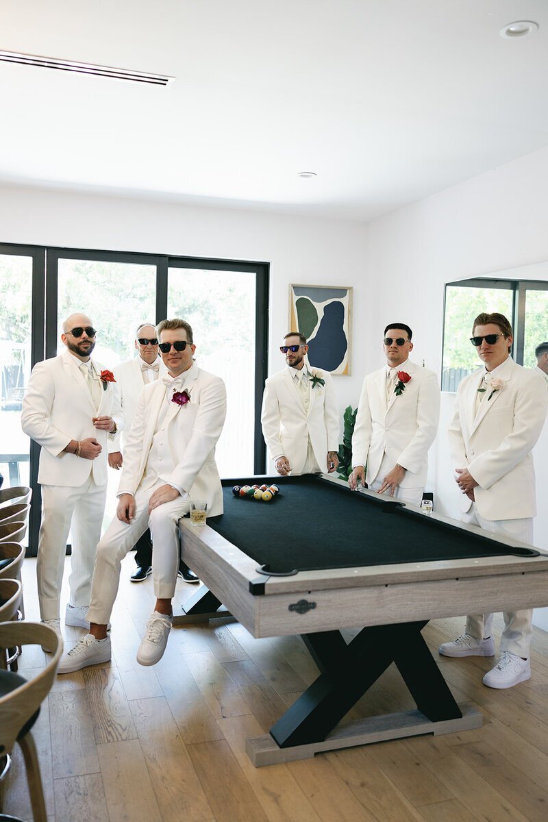 groomsmen sitting around pool table at the penthouse at riverside wharf​