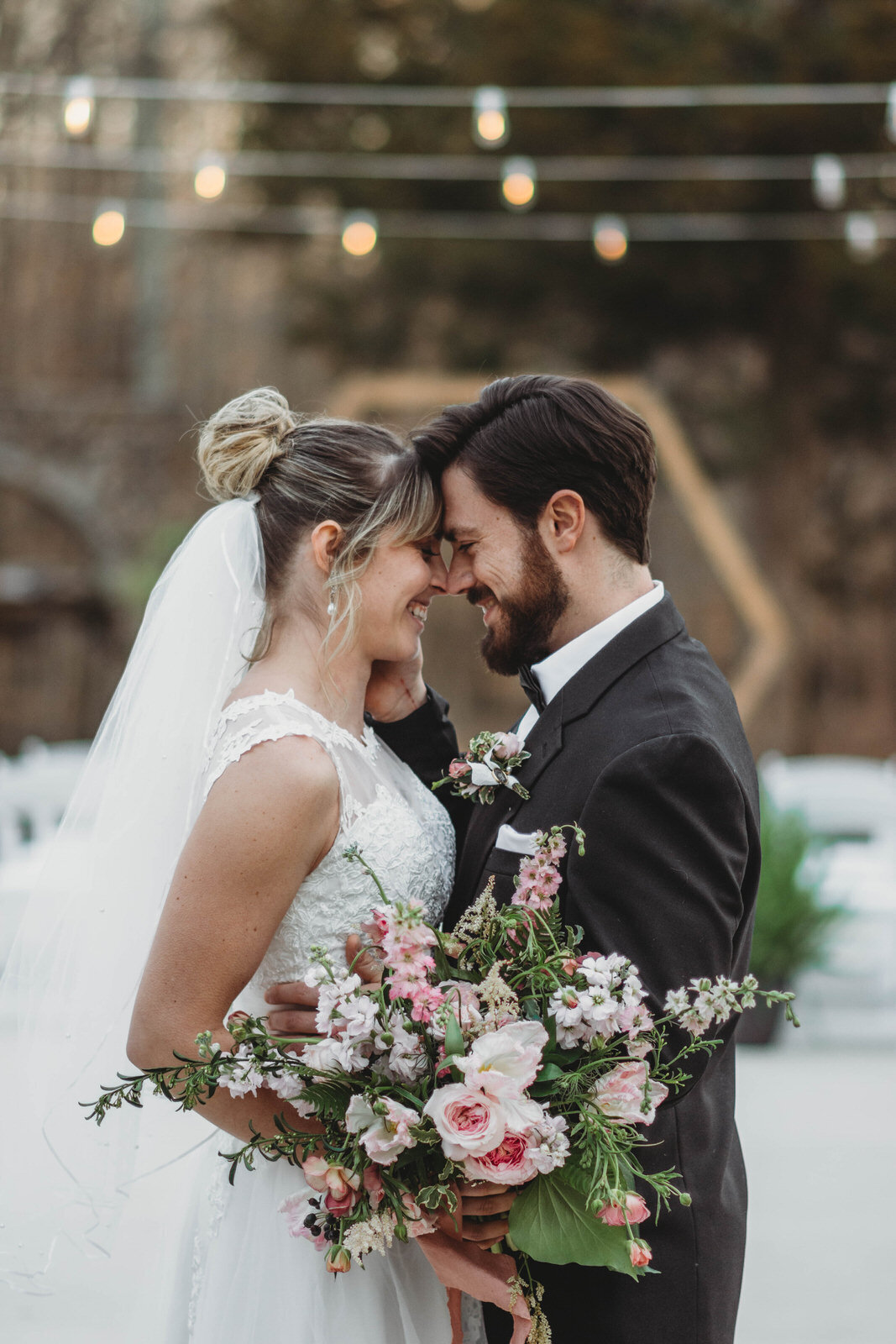couple-smiling-under-string-lights