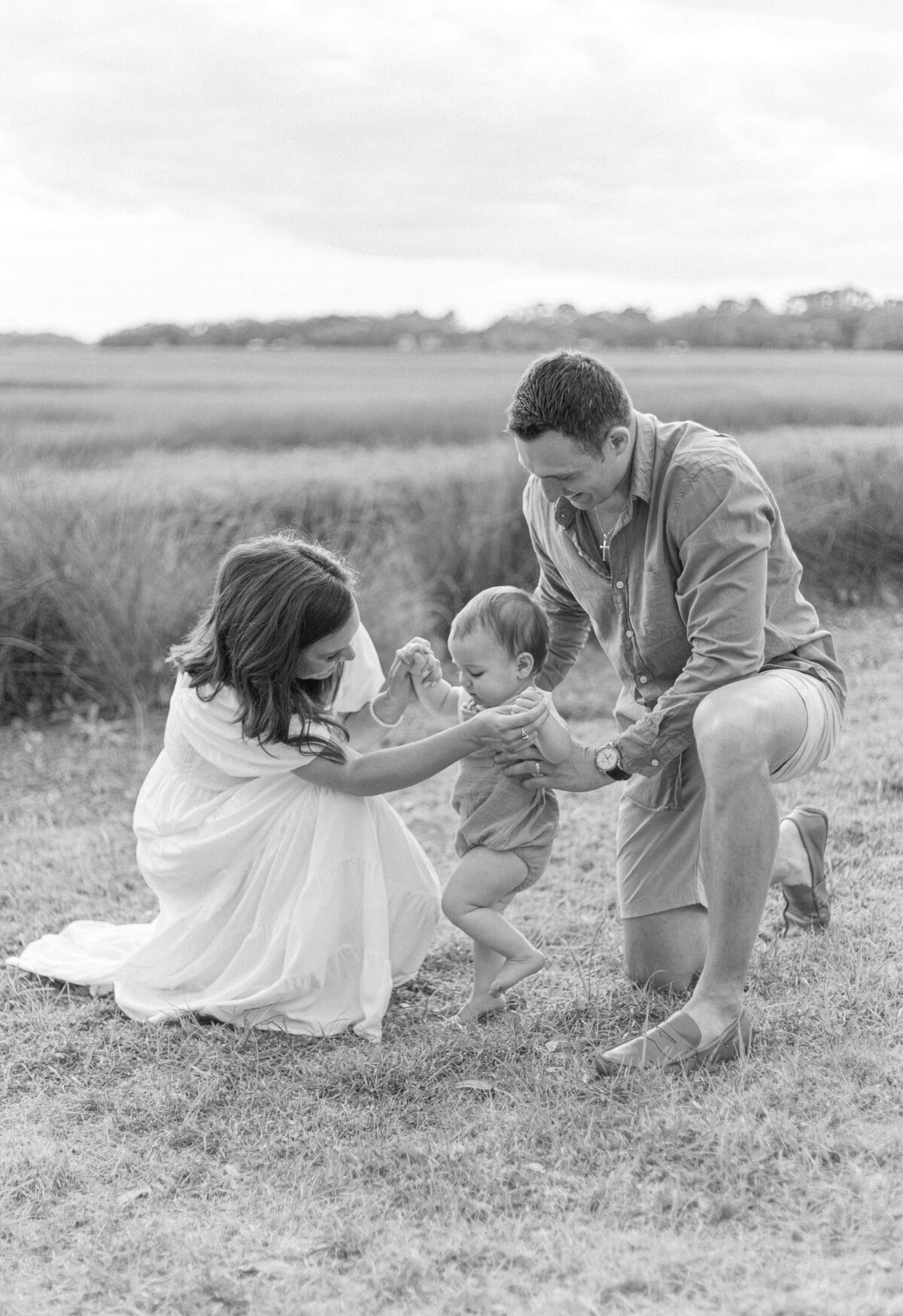 Mom and Dad are helping their baby boy take his first steps on the marsh at Sea Pines Country Club for Hilton Head Photographer, Lamp and Light Photography.