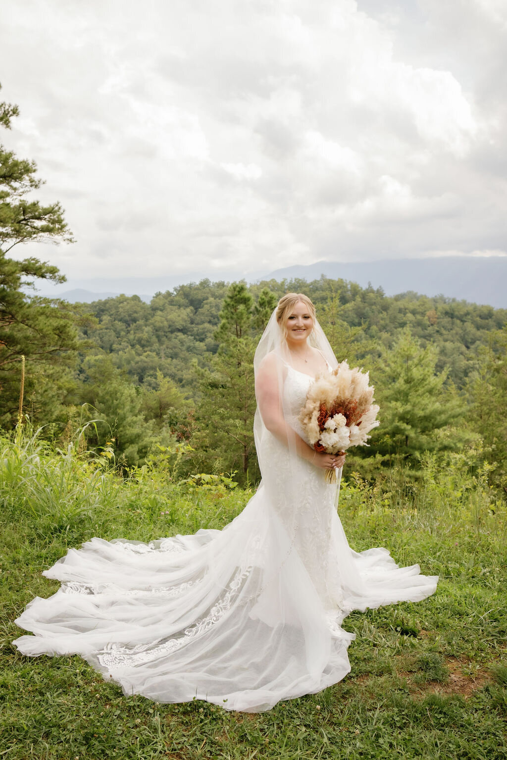 bride holding a boho wedding bouquet for a bridal portrait on the foothills parkway overlook