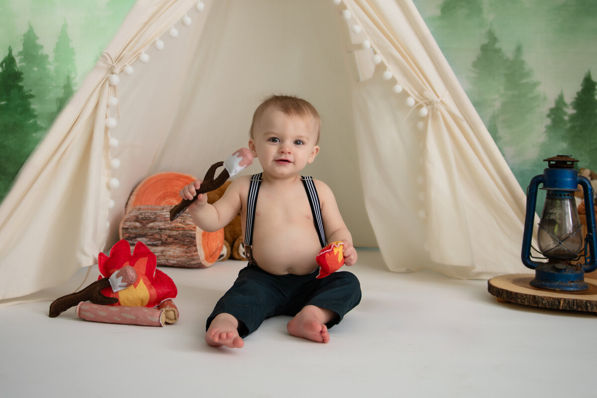 boy celebrating first birthday with campfire picture